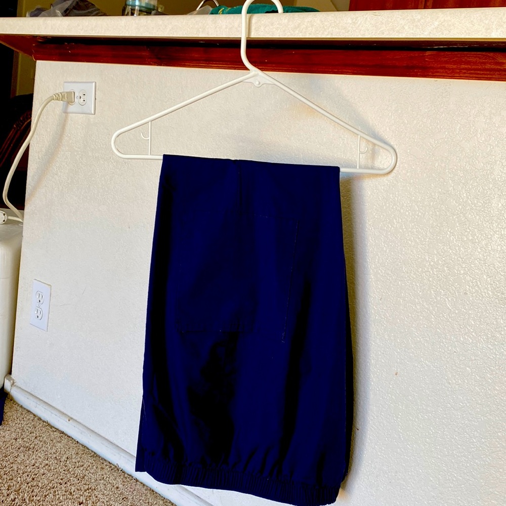 Navy blue medium scrub pants. Patch side pockets & small slits at the hem.